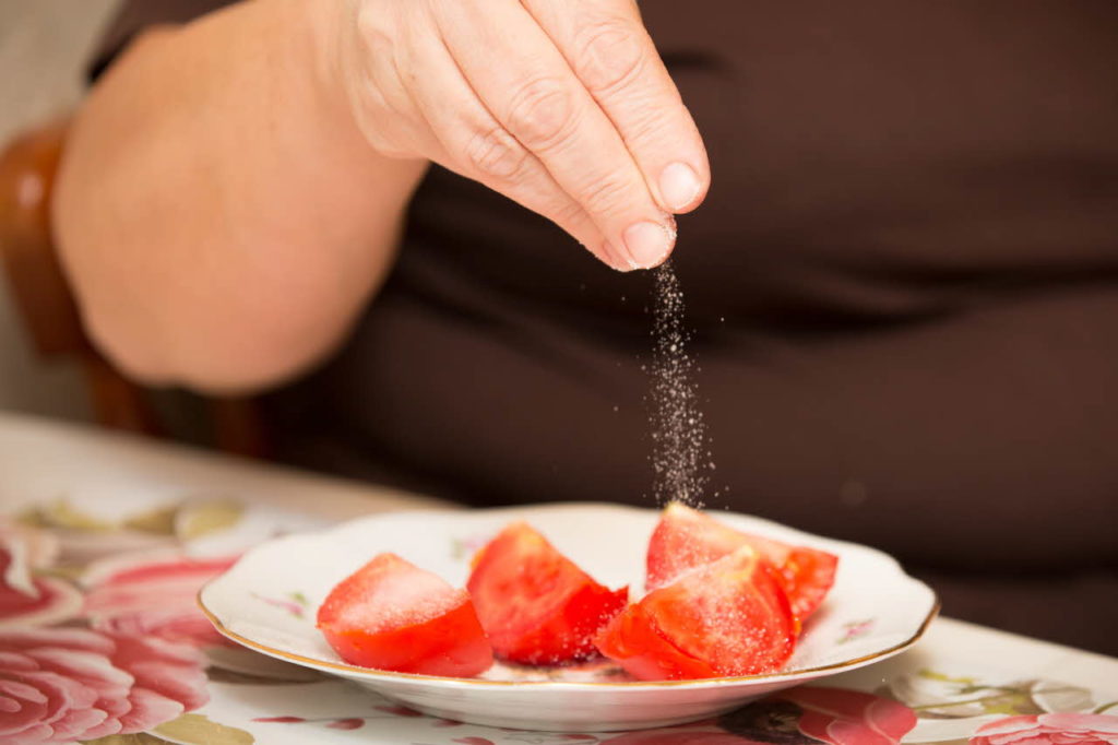 Sprinkling salt on tomatoes