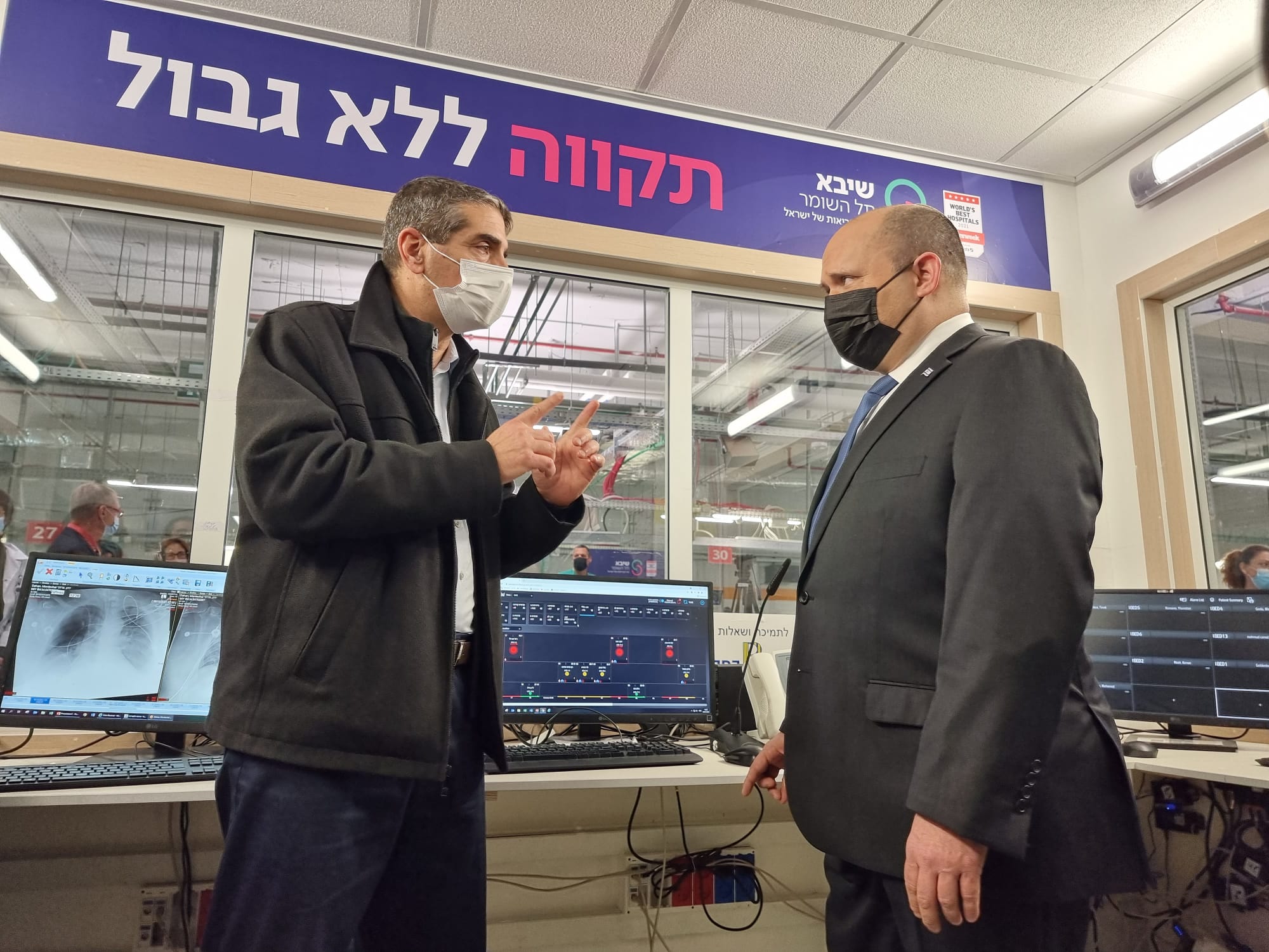 Israeli Prime Minister Naftal Bennett (right) is briefed about Sheba Medical Center's COVID-19 fourth shot trial on Tuesday, January 4, by hospital Director-General Prof. Yitshak Kreiss.