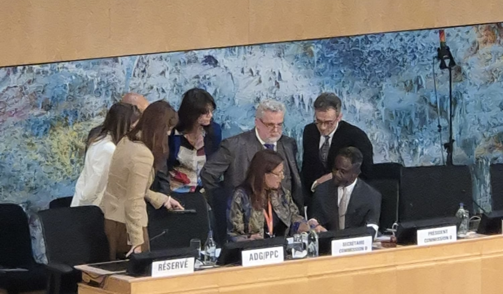 Delegates and the secretariat huddle to negotiate the complex legal text of resolutions on Argentina's withdrawal notification.